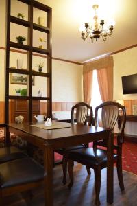Hansa Apartment في تارتو: غرفة طعام مع طاولة وكراسي خشبية