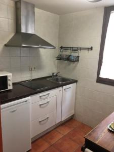 a kitchen with a sink and a microwave at Hostal Rural La Botería in Sacedón