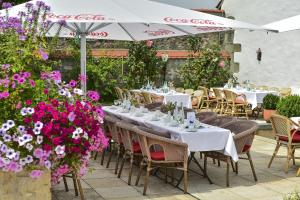 a restaurant with white tables and chairs and flowers at Schloss Hotel Wasserburg in Wasserburg am Bodensee