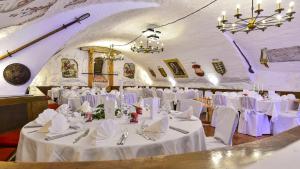 ヴァッサーブルクにあるシュロス ホテル ヴァッサーブルクの白いテーブルと椅子が備わる宴会場