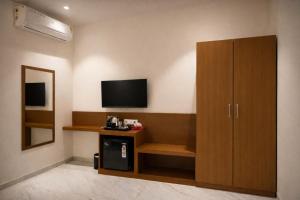a living room with a television and a cabinet at Solasta Stays and Banquet - Wakad in Pune