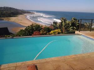 a swimming pool with a view of the beach at Dinvorae in Southbroom