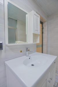 a white bathroom with a sink and a mirror at First encounter with a homestay in Fenghuang County