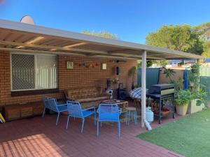 a patio with a couch and chairs and a table and a piano at Ocean Drive Home: 3 bedroom 70s-inspired… - 19110 in Bunbury
