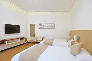 a hotel room with two beds and a flat screen tv at First encounter with a homestay in Fenghuang County