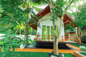 a house in the middle of a garden with trees at Kurumba Luxury Cabin in Ahangama