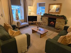 a living room with two couches and a fireplace at End Cottage in Skipton