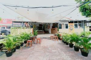 a patio with tables and chairs and potted plants at Hotel Safara Yogyakarta in Yogyakarta