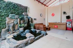a lobby with a pond in the middle of a room at Hotel Safara Yogyakarta in Yogyakarta
