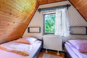 two beds in a small room with a window at Hugo's House in Rakitna