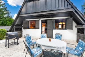 a patio with a table and chairs and a grill at Hugo's House in Rakitna