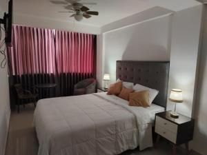 a bedroom with a bed and a table with a chair at Hostal Mirador in Pisco +21 photos