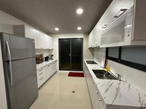 a kitchen with white cabinets and a stainless steel refrigerator at Lan Yang Resort Four Seasons in Dongshan