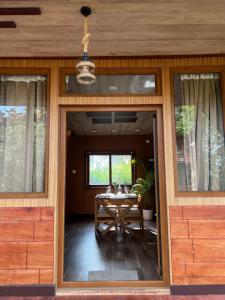 a dining room with a table and a glass door at Jungle flare in Hampāpura