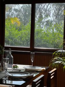 a table with glasses and plates on it with a window at Jungle flare in Hampāpura