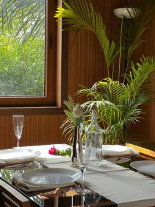 a table with white plates and a glass bottle on it at Jungle flare in Hampāpura