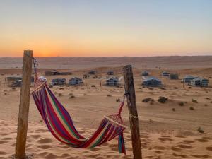 a hammock on two poles in the desert at Endless Dunes Camp in Badīyah