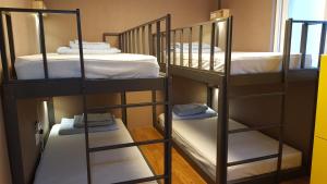two sets of bunk beds in a small room at Seri Inn Guesthouse in Busan