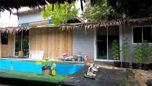 a house with a swimming pool in front of it at Row House Long Beach in Ko Lanta