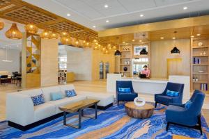 a lobby with a white couch and blue chairs at Hyatt House across from Universal Orlando Resort in Orlando