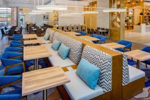a restaurant with wooden tables and blue chairs at Hyatt House across from Universal Orlando Resort in Orlando
