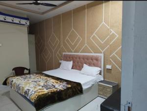 a bedroom with a large bed with white sheets at Malti palace in Sāgar