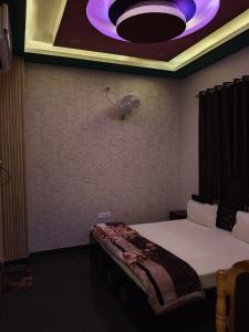 a room with a bed and a ceiling with a fan at Malti palace in Sāgar
