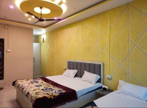 a bedroom with a bed and a yellow wall at Malti palace in Sāgar