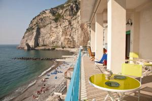 a view of a beach with a yellow table and chairs at terrazza metese in Meta
