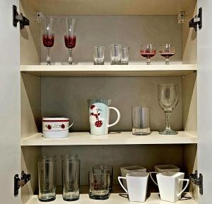 a shelf filled with glasses and wine glasses at Apartament Lipnicki 2 in Bielsko-Biała +9 photos