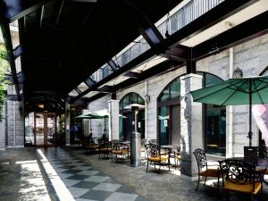 eine leere Terrasse mit Tischen, Stühlen und einem Sonnenschirm in der Unterkunft Five Hotel Osaka in Osaka