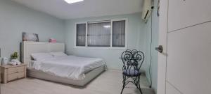 a bedroom with a bed and a chair and a window at Shanel House in Incheon