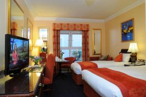 a hotel room with two beds and a flat screen tv at Park House Hotel in Galway