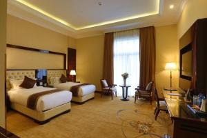 a hotel room with two beds and a television at Sapphire Addis in Addis Ababa