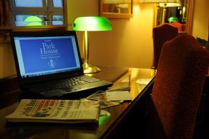 a laptop computer sitting on a desk with a book at Park House Hotel in Galway
