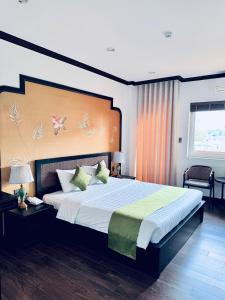 a bedroom with a large bed with a large headboard at Biet Dien Hotel in Buon Ma Thuot +55 photos