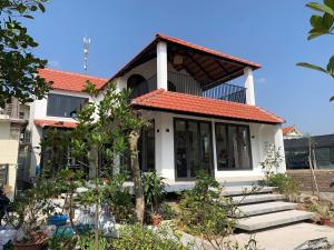 a small white house with an orange roof at The Little Home in Xuân Dục