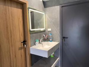 a bathroom with a white sink and a mirror at The Little Home in Xuân Dục