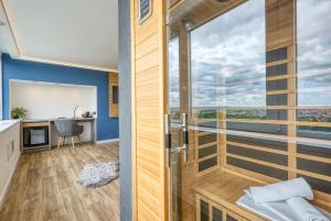 a room with a glass door with a desk and a view at Hotel Szieszta in Sopron