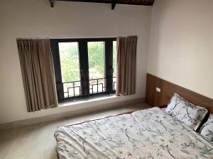 a bedroom with a bed and a large window at The Little Home in Xuân Dục +9 photos