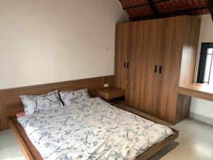 a bedroom with a bed and a wooden cabinet at The Little Home in Xuân Dục