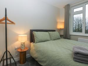 a bedroom with a bed and a window at Caledfryn in Benllech