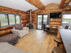 a living room with a couch and a table at Douglas Cabin at Salford Court Farm Fishing Cabins in Worcester