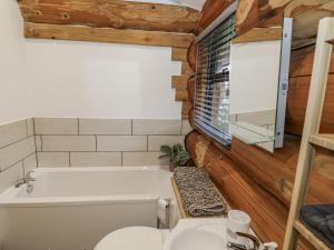 a bathroom with a tub and a toilet and a sink at Douglas Cabin at Salford Court Farm Fishing Cabins in Worcester +16 photos