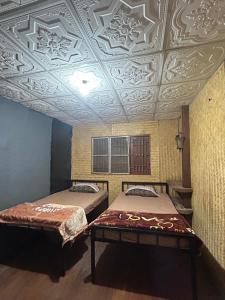 two beds in a room with a coffered ceiling at Whatsup pai in Pai