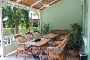 a patio with two tables and chairs on a porch at Family Apartman in Gyula