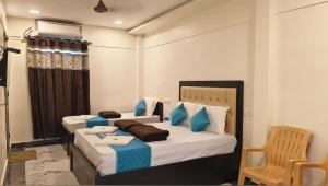 a bedroom with two beds and a chair in it at RCH Home Stay in Rāmeswaram