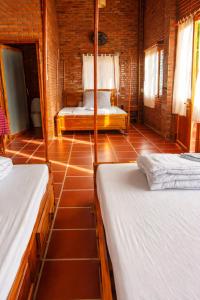 a bedroom with two beds and a tiled floor at Dream Hill Homestay in Cat Tien