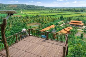 a wooden balcony with a view of a valley at Dream Hill Homestay in Cat Tien