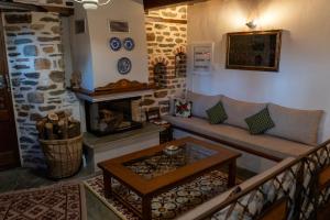 a living room with a couch and a fireplace at Αρχοντικό Μελλιώ Άγιος Λαυρέντιος in Agios Lavrentios